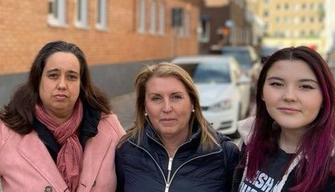 Tre kvinnor håller om varandra